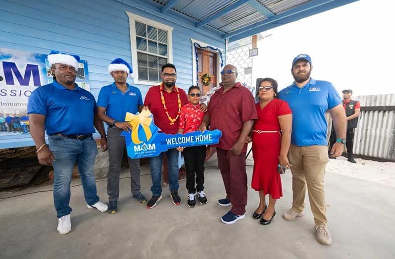 President Dr Mohamed Irfaan Ali, together with 46-year-old James Hercules and his family, at the simple handing over ceremony on Christmas Day