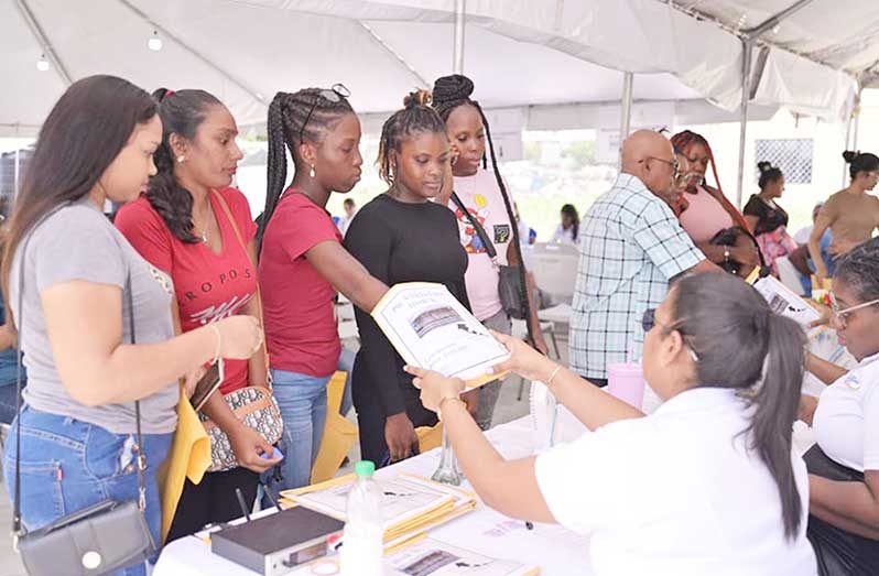 Allotees pull their lot numbers on Friday at the Ministry’s Regional Office in Pouderoyen, West Bank Demerara