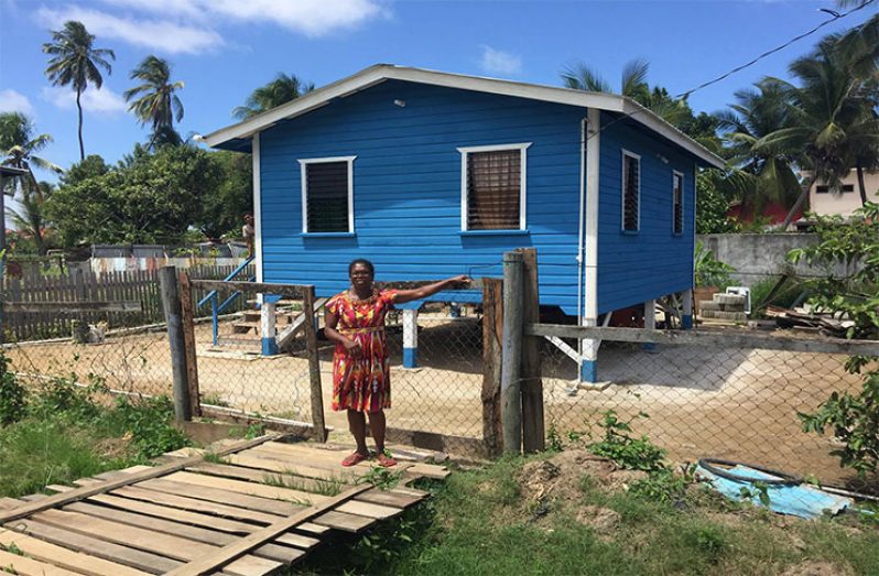 Jennifer Henry stands infront of her newly constructed home which was donated by Food for the Poor Guyana