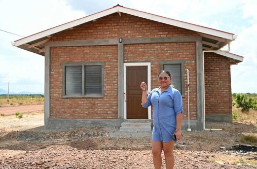 A woman proudly holds the keys to her newly constructed home. Women received 1,547, or nearly half, of the 3,245 house lots allocated by the government during the first half of 2026