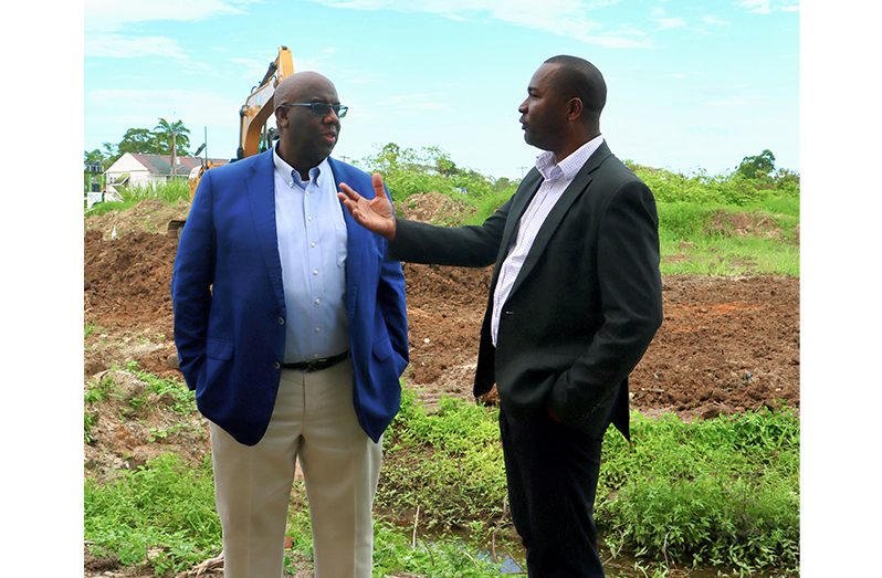 Guyana Football Federation president,, Wayne Forde (right), in discussion with CONCACAF’s Howard McIntosh at the construction site