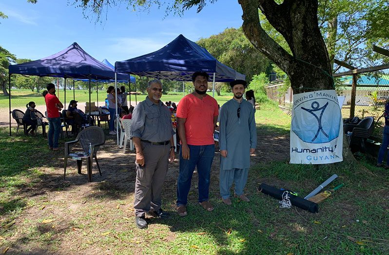Humanity First Guyana Country Director, Jameel Mohamed (left) and Humanity First Guyana Chairman, Maqsood Ahmed Mansoor (right) with a volunteer at the summer camp on Thursday last