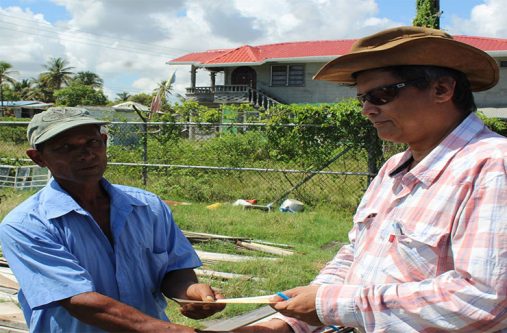 IAC Executive Member Evan Radhay Persaud presents monetary donation to high winds victim Mr. Allimudeen Gobin.