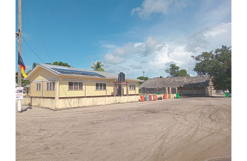 The newly constructed building powered by solar energy, with the traditional benab nearby.