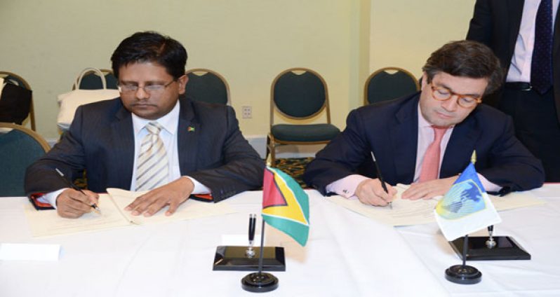 Minister of Finance, Dr Ashni Singh (left) and IDB President, Luis Alberto Moreno inking the loan agreements last Thursday in the Bahamas