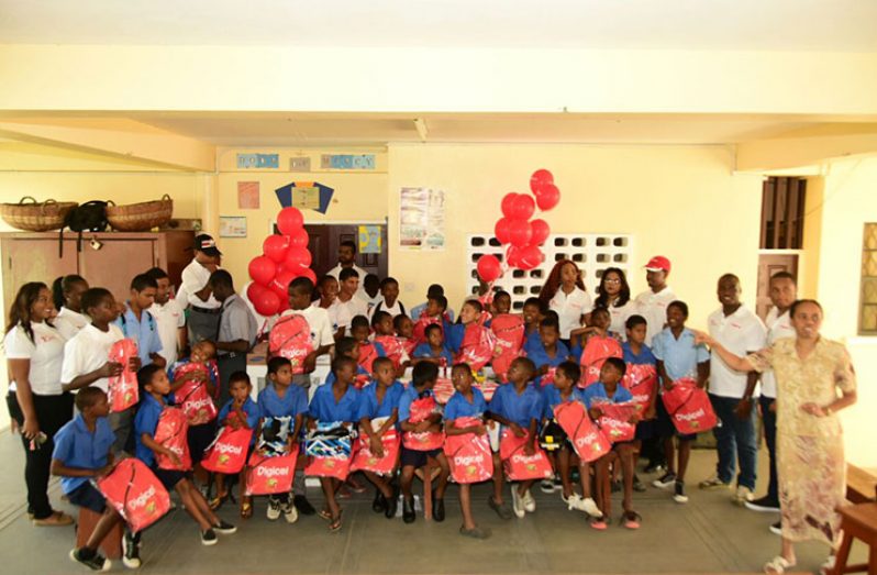 The boys of St. John’s Bosco Orphanage flanked by Digicel Guyana staffers at St. John’s Bosco Boys Orphanage on Tuesday during a visit