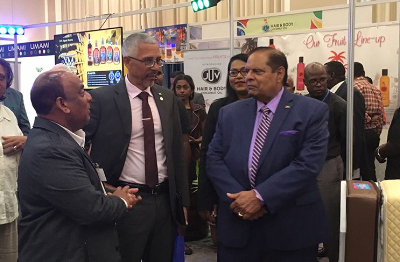 Mr. Dennis Charran, Comfort Sleep CEO (at left) engages in brief discussion with Min. of Business, Dominic Gaskin and Prime Minister Moses Nagamootoo, during the GuyTIE Exhibition on Thursday