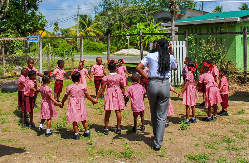 A few cheerful students and their teacher at the Cottage Primary School (Shaniece Bamfield Photos)