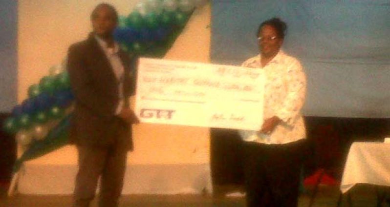 Director of Habitat for Humanity Guyana, Mr. Rawle Small (left) collects the cheque for $1M from a GT&T representative