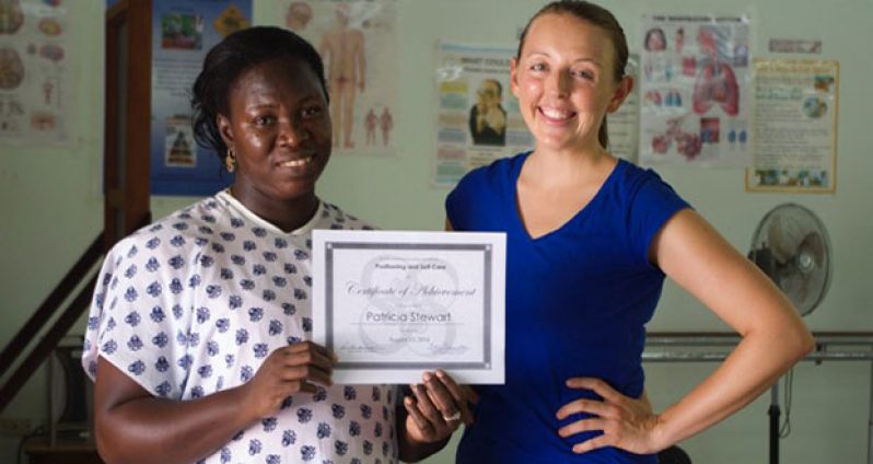 Nurse Aide, Patricia Stewart and Peace Corps Response Volunteer, Kera Murphy, celebrating Ms. Stewart receiving a certificate after demonstrating resident care skills in positioning and self-care following training