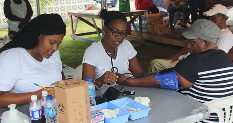An elderly woman having her blood pressure tested by one of the medical personnel at the outreach on Saturday