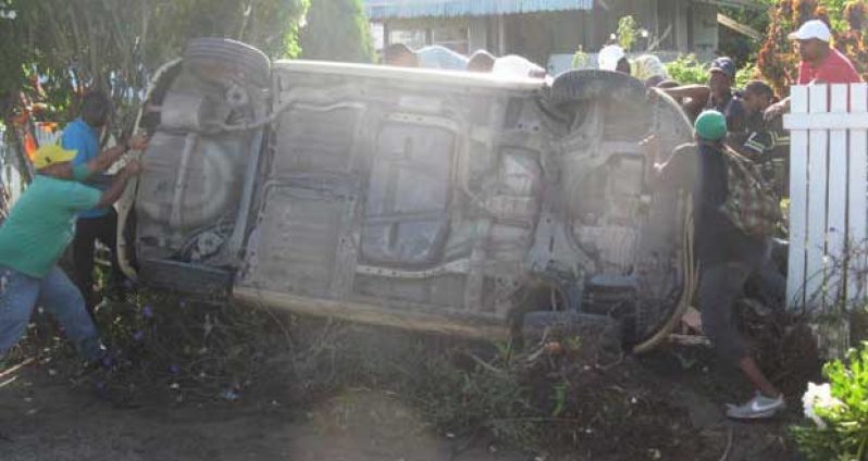 Public-spirited citizens assist in righting the overturned vehicle