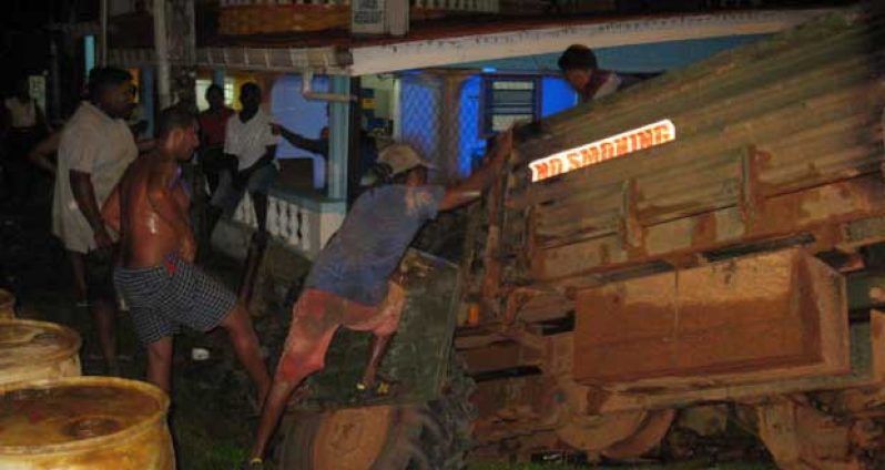 Public spirited citizens assist in off-loading barrels from the truck’s tray