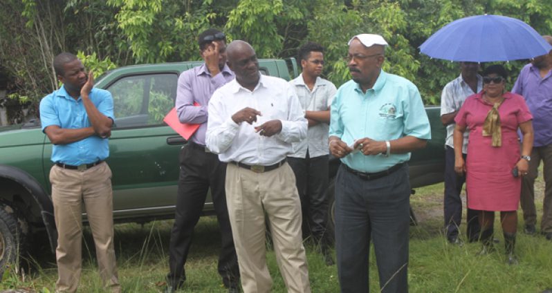 Local Government and Regional Development Minister, Mr. Norman Whittaker, with other officials to observe works being done in the cemetery in the drizzling rain