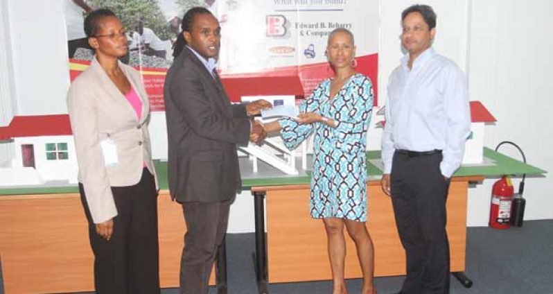 Habitat’s Mr Rawle Small receives the cheque from Mrs Anjuli Beharry in the presence of Beharry’s Chairman, Mr Anand Beharry (right) and a representative of Habitat for Humanity