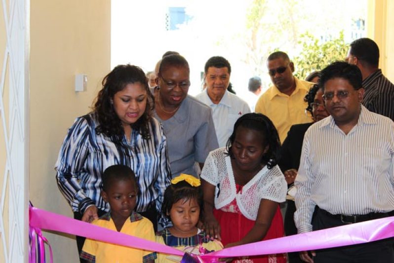 Education Minister, Priya Manickchand (left) and Finance minister, Dr. Ashni Singh join some of the children in the symbolic cutting of the ribbon to commission the Beterverwagting Nursery School