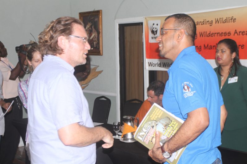 Minister Persaud interacts with Mr. Jon Parsons of the Global Canopy Program (GCP) during the closing session of the South-South international exchange workshop on Community Measurement Reporting and Verification (CMRV)for REDD+ yesterday.
