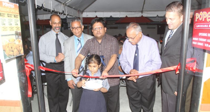 Finance Minister, Dr. Ashni Singh, with the Chairman of Guyana Restaurants Inc., R. L. Singh, fourth from left, with other stakeholders during the ceremonial ribbon cutting