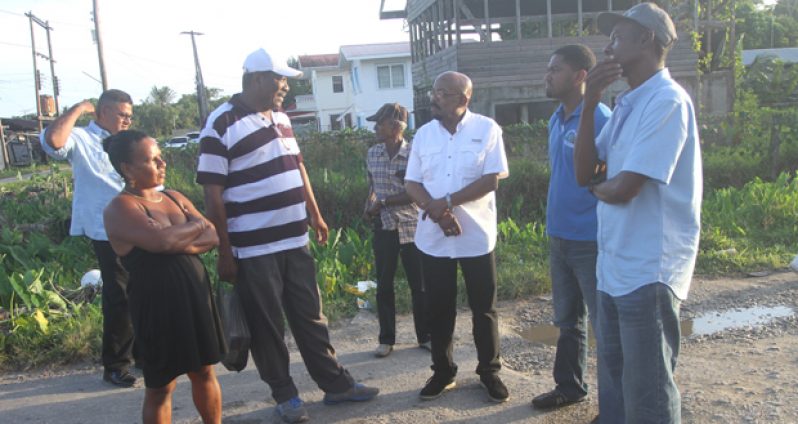 Minister of Local Government and Regional Development, Mr. Norman Whittaker examines the reduced flow of the Mon Grepo Creek with IMC Chairman, Mr. Ovid Benjamin