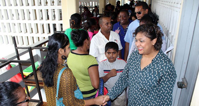 Education Minister, Ms. Priya Manickchand greets parents as they come to uplift their grant vouchers