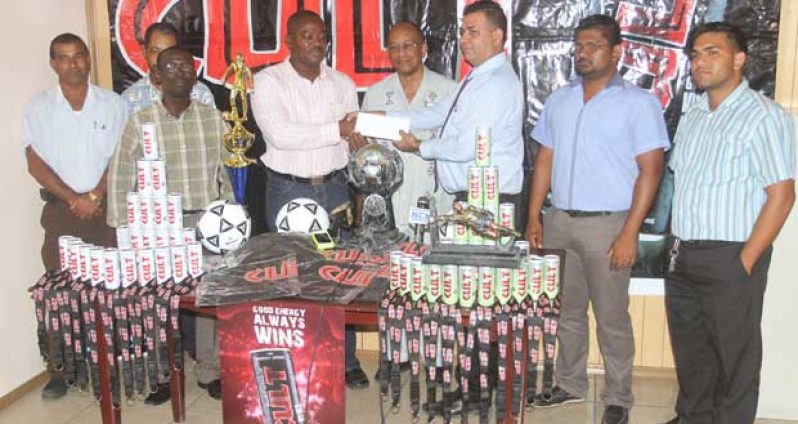 Continental Group of Companies Office Manager Chaitnarine Brijnandan presents the sponsorship cheque of an undisclosed sum to EBFA secretary Franklin Wilson, in the presence of other football and company officials. (Sonell Nelson photo)
