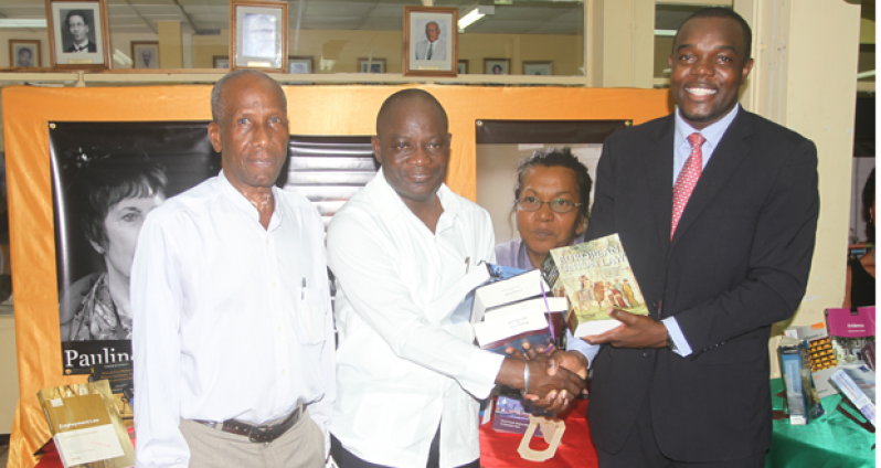 Mr. Eusi Anderson (right) hands over the donated law books to Professor Jacob Opadeyi (centre), in presence of the UG Head of Department of Law, Mr. Sheldon McDonald.