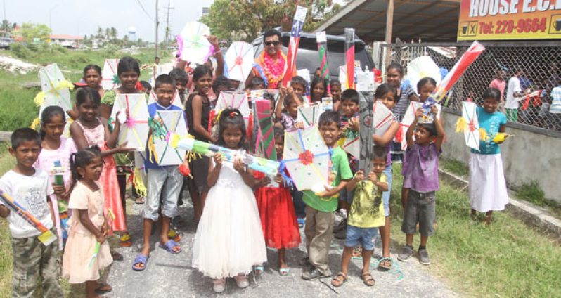 Nandlall with some of the children yesterday after they had received their kites (Sonell Nelson photo)