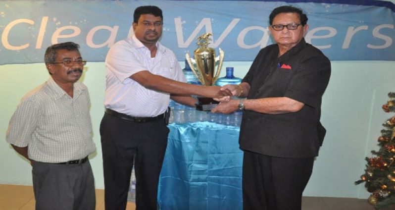 Retired Chief Justice Cecil Kennard (right) accepts the winning trophy for the J3 event from IPA CEO Lloyd Singh in the presence of IPA manager Bowhan Balkarran.