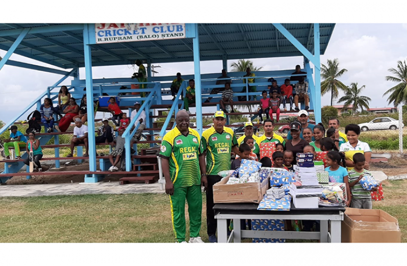 Manager Ian John and Mahendra Hardyal (extreme left) display some gifts in the presence of the beneficiaries.