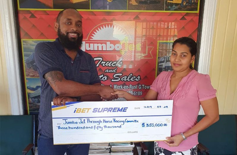 : iBet Supreme’s Business Development Manager and Marketing Coordinator, Dustanni Barrow, hands over the sponsorship cheque to Jumbo Jet’s Gaitree Tulsidas.