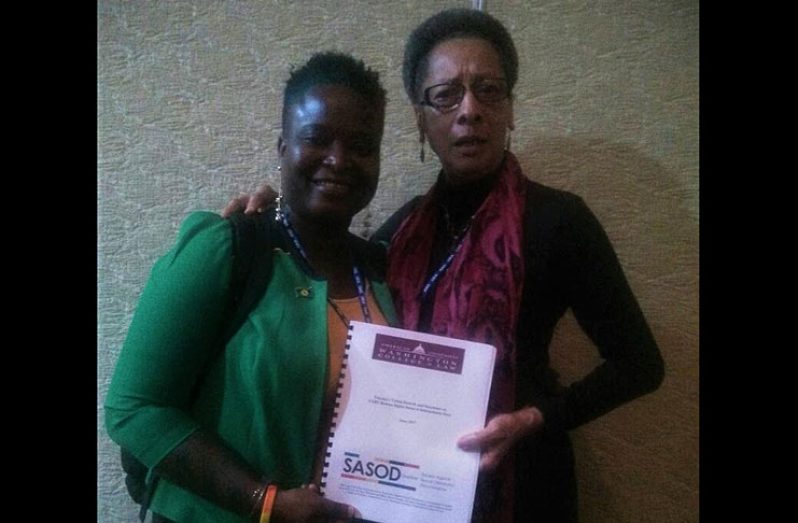 First Vice-President and Rapporteur for Guyana of the Inter-American Commission on Human Rights, Margarette May Macaulay (right), receives a copy of SASOD's recent LGBT Human Rights Report from SASOD member and volunteer Terianna Bisnauth.
