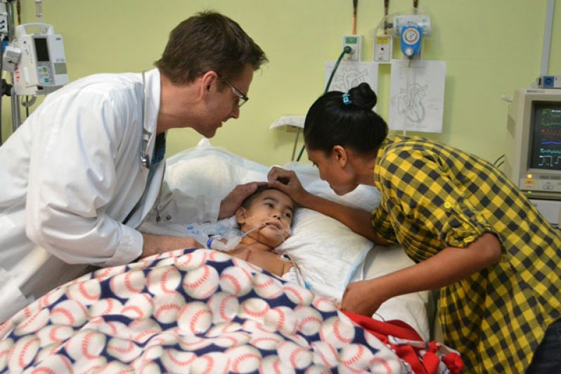 A patient recovering and being comforted by his mother and a doctor