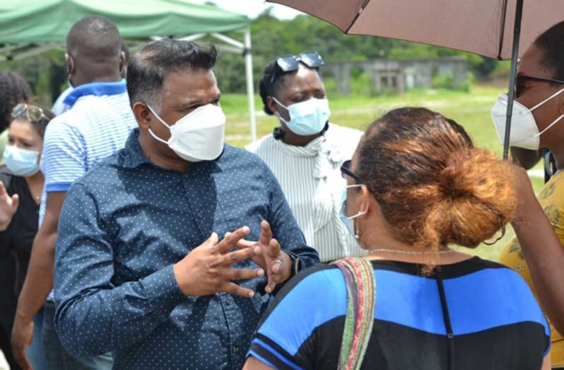 Minister within the Ministry of Public Works, Deodat Indar engaging one of the residents of the community