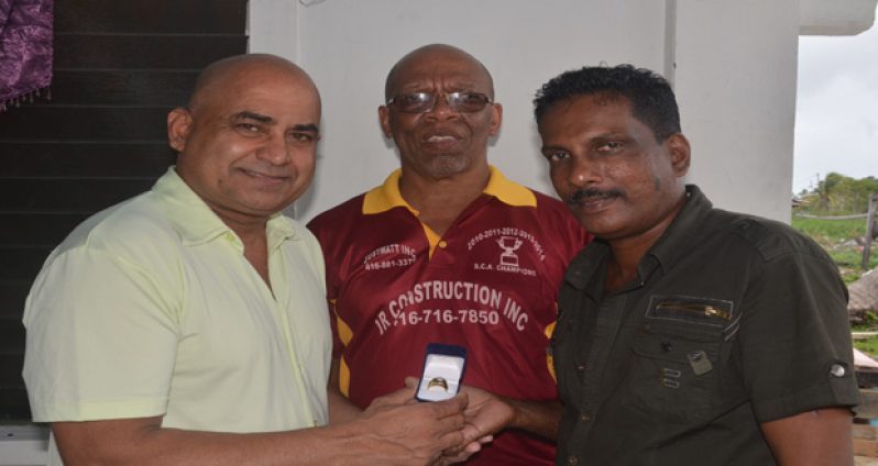 Cricket commentator Inderjeet Persaud receives a HACC championship ring from president Narchand ‘Archie’ Mohan. At centre is HACC manager Frederick Halley.