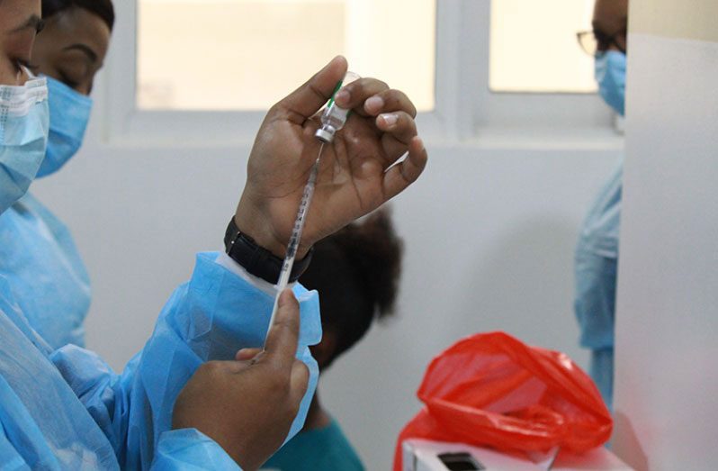 A nurse at the National Infectious Diseases Hospital at Liliendaal, Greater Georgetown, preparing to administer a dose of the Oxford-Astrazeneca vaccine to a local healthcare worker (Vishani Ragobeer photo)