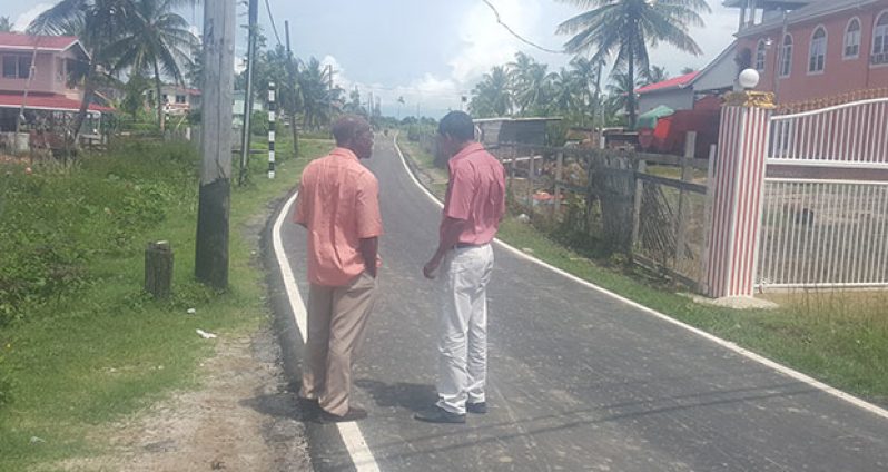 Regional Executive Officer (REO) Ovid Morrison (left) and Regional Engineer Dhanpaul Sukha on site at a newly-asphalted road at Woodley Park, West Coast Berbice