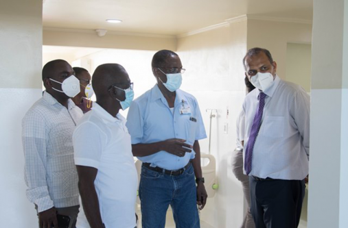 Health Minister, Dr. Frank Anthony being given a guided tour of the COVID-19 hospital by Director of Medical and Professional Services, Dr. Fawcett Jeffrey, and CEO of the GPHC, Brigadier Retired George Lewis. Also in the photo is Minister of Public Affairs within the Office of the Prime Minister, Kwame McCoy, along with other officials from the GPHC (DPI photo)