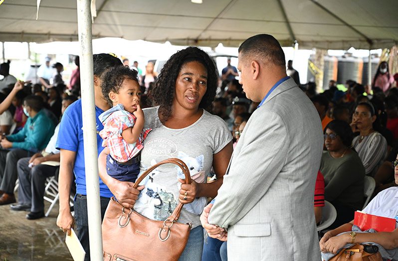 Minister of Housing and Water, Collin Croal, interacts with one of the many applicants at the final ‘Dream Realised’ Housing Drive for the year 2022, at the Arthur Chung Conference Centre