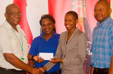 Athletic star Aliann Pompey receives the sponsorship cheque from Brand Manager Clive Pellew while Meet official Mayfield Taylor-Trim and Banks DIH’s Kester Van-Nooten look on.