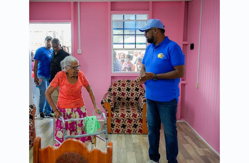 President, Dr Irfaan Ali (right) and 85-year-old Meena Bafan (left) in the newly built home (Office of the President Photo)