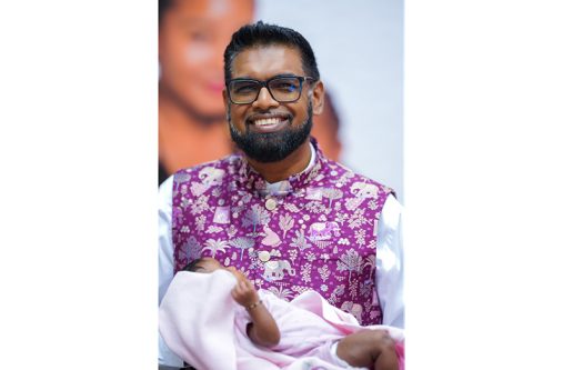 President Dr. Irfaan Ali with a newborn