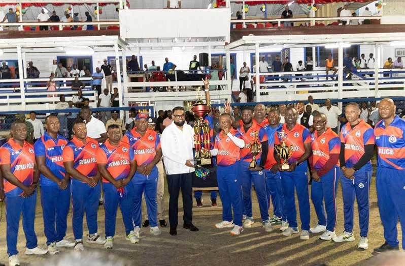 Commander-in-Chief, President Irfaan Ali, hands over the winning trophy to GPF skipper, Deputy Commissioner (Administration), Ravindradath Budhram in the presence of the other players.
