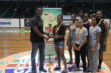 YBG’s Co-Director Ryad Boyce presenting the winner’s trophy to MVP and Marian Academy’s Captain Jada Mohan.