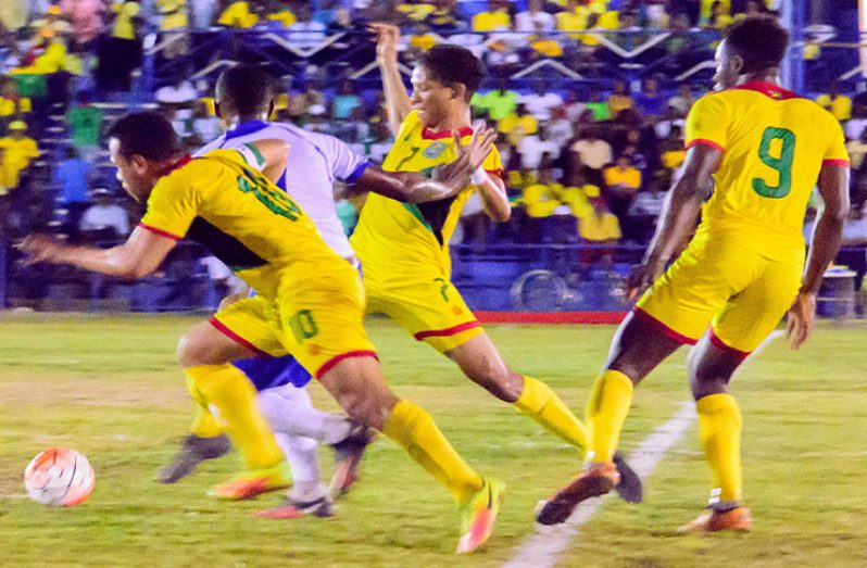 Golden Jags skipper Sam Cox (#10), Marcel Barrington (#7) and Brandon Beresford battling a Martinique player during their clash at the MSC Ground in Linden (Samuel Maughn Photo)