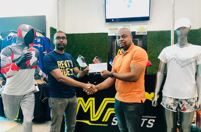 Edison Jefford (right) accepts the sponsorship from MVP Sports Manager, Ian Ramdeo, at the store in Giftland Mall.