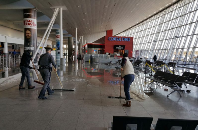 Workers mopping up after a massive water main break at the Kennedy Airport on Sunday caused chaos and a shutdown of its international arrivals terminal — the latest in a series of misfortunes to befall travellers, some of whom are Guyanese, have been stranded for days (New York Post photo)