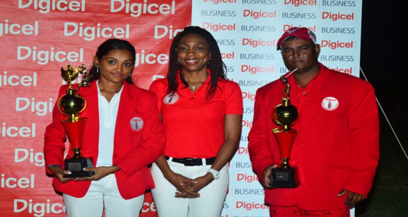 Digicel Marketing Manager Jacqueline James (centre) is all smiles as she strikes a pose with the 2014 Digicel Open Golf Classic champions Joann Deo (left) and Avinash Persaud, who are well decked out in their ‘Red Jackets’. (Photo by Adrian Narine)