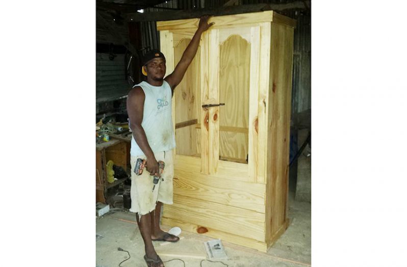 Adrian Jacobs with a wardrobe he built