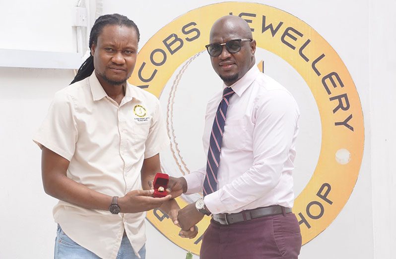 Dellon Caesar (L) presenting one of the four championship rings to tournament organiser, Rawle Toney at Jacobs Jewellery and Pawn Shop Pike Street location.