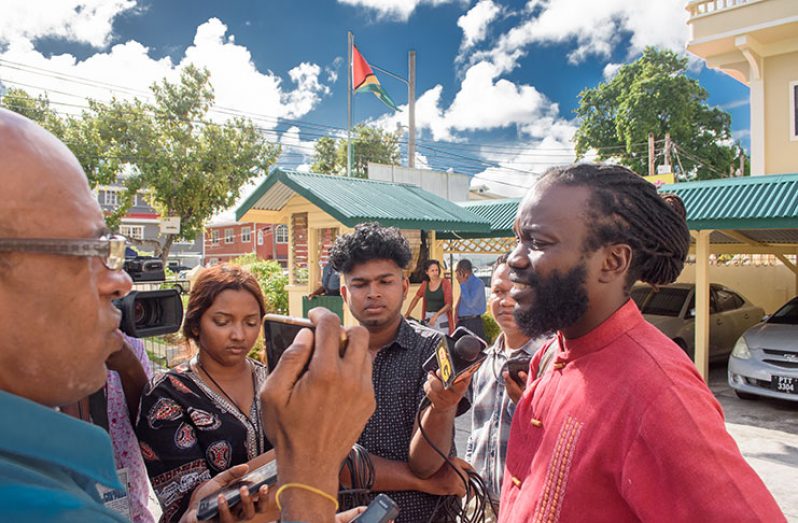 Activist, Mark Jacobs, speaks with members of the media outside the Ministry of the Presidency, following a meeting with Minister of Citizenship, Winston Felix, on Wednesday